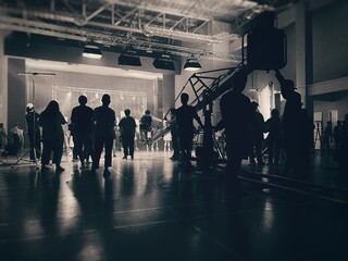 Behind the scenes of music video shooting production crew team silhouette and camera equipment in...