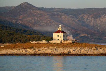 Fototapeta na wymiar Picturesque lighthouse on small island near Hvar, Croatia.