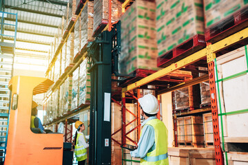 Working Team at warehouse. Manager use Tablet Information to further placement in storage department and asian woman warehouse workers.background driver at Warehouse forklift loader works with goods