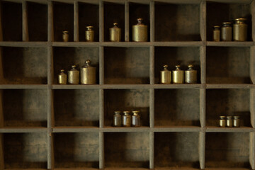 Small vintage brass weights displayed in letterpress drawer. 