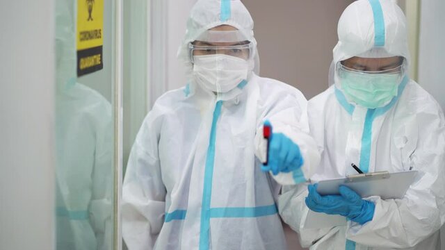 Asian doctor holding checking coronavirus or covid-19 infected patient name list sheet in quarantine area in hospital. Corona virus, Covid 19 virus outbreak, medical mask or virus outbreak concept