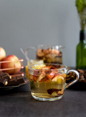 Composition of tea drinking. On a dark background, tea with dried fruits, apples, honey and chocolate. Antiviral kit. Side view 