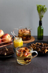 Composition of tea drinking. On a dark background, tea with dried fruits, apples, honey and chocolate. Antiviral kit. Side view 
