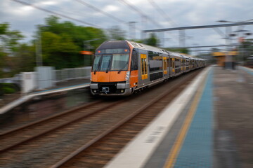 Sydney Train heading through Summerhill Station with background motion blur NSW Australia