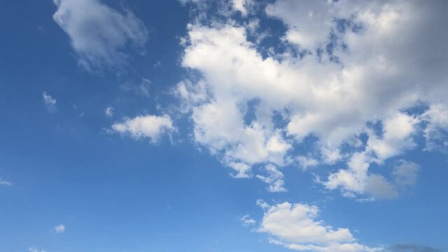 Puffy fluffy white cloud n cotton candy cumulus cloudscape slowly moving on beautiful sunny clear blue sky background in tropical summer or spring sunlight n sun ray, 4k cinemagraphs b-roll TimeLapse