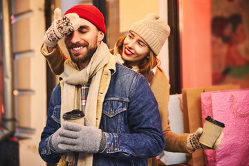 Jolly bearded guy drinking coffee with girlfriend outdoors