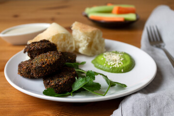 Protein lunch falafel vegetables carrots and celery bread tortilla and basil sauce