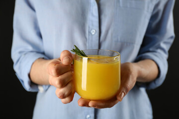 Woman holding cup of immunity boosting drink in hands, closeup
