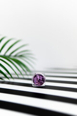 lilac small jar of sparkles on a striped background. composition of fashion cosmetics. sparkles 