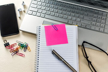 Business concept with Notebook with small note paper, laptop and office supplies.