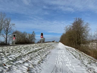 Fotobehang Snowy bicyle path towards the bridge over the Prinses Margriet canal © TravelTelly