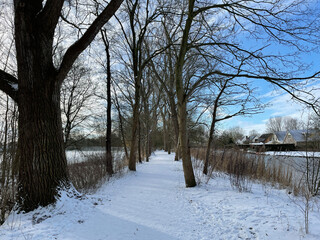 Snow on a path next to a frozen canal in Sneek