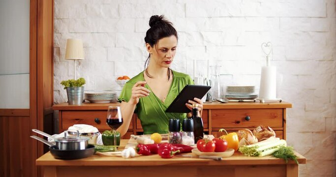 Beautiful woman checks the recipe for spring food on the tablet