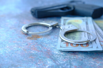 Close up of handcuff, cash and pistol on black background.