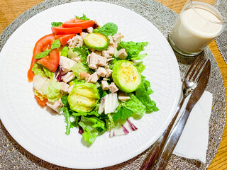 Dietary food, salad leaves with zucchini slices, tomatoes and slices of turkey fillet