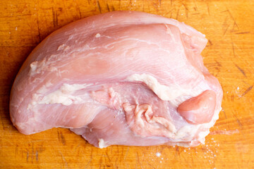 Raw turkey fillet on a cutting board.