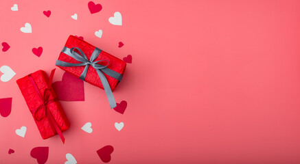 Two gifts for valentine's day. Boxes in red packaging on a pink background with hearts. Banner. Place for your text.