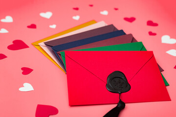 Love letters. Multicolored envelopes on a red background with hearts.