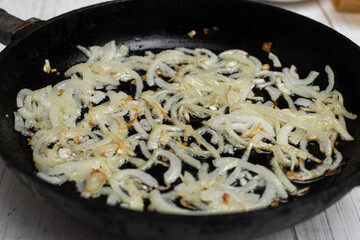 Fried onions in a pan. Cooking ingredient.