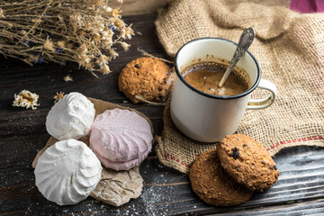 Homemade zephyr, cookies and a cup of coffee on wooden rustic background