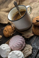 Homemade zephyr, cookies and a cup of coffee on wooden rustic background