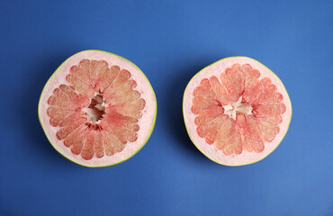 Fresh cut pomelo fruit on blue background, flat lay