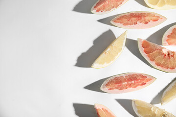 Slices of different ripe pomelos on white background, flat lay. Space for text