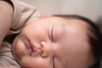 close up asian baby infant face closing eyes sleeping on bed. chubby cheek.