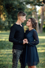 Cheerful young woman and man are hugging outdoor in summer park. Dating and romantic vacation. couple in love gently looking at each other on sunny day