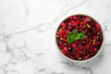 Traditional Russian salad vinaigrette on white marble table, top view. Space for text