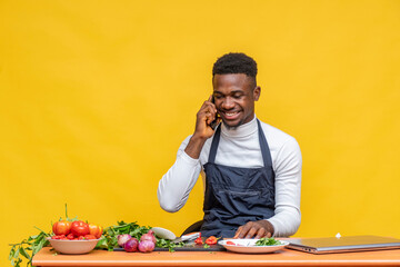 african chef smiling while making a phone call