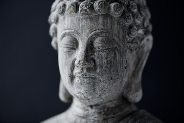 Meditating Buddha Statue on dark background. Close up.