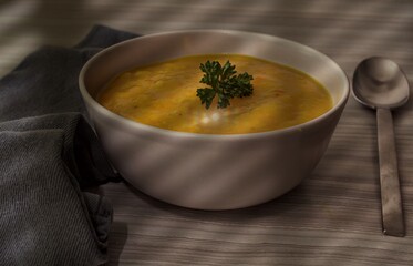 Schüssel Kürbissuppe mit Petersilie im Schatten 