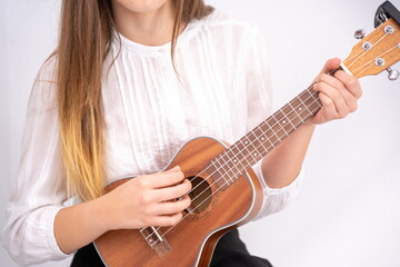 Young woman with guitar on white background with copy space