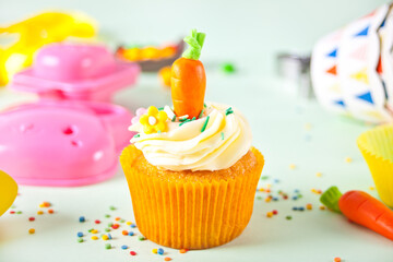 Easter funny cupcake with candy carrot. Easter celebration festive table.
