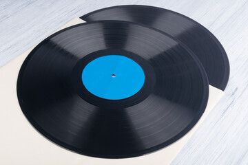 on a light gray background, on a paper envelope, are two vinyl records, background