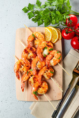  Grilled prawns on wooden skewers, shrimp kebab. Top view, vertical photo