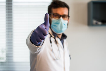 Fototapeta na wymiar Close up of male doctor showing thumbs up gesture. Health care, people and medicine concept. Operation completed successfully
