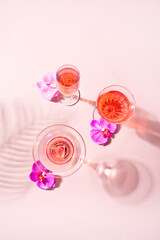 Summer tropical pink cocktail in a different glasses decorated pink orchid flowers. Top view.