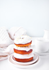Doughnuts on the plate glazed white chocolate cream or icing and bottle with milk on the background.