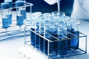 Scientist pipetting samples into test tubes in the microbiology laboratory. Researcher working with tubes in chemistry lab