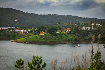Fototapeta na wymiar Landscape view of Castelo de Bode waterdam in Portugal. Houses on the riverside of Zezere river