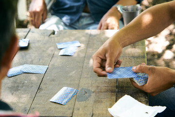 Personas Latinoamericanas jugando a las cartas de truco al aire libre. Familia jugando