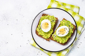 Avocado Sandwiches with Boiled Egg and Cereal Bread on white background, top view. Healthy breakfast.