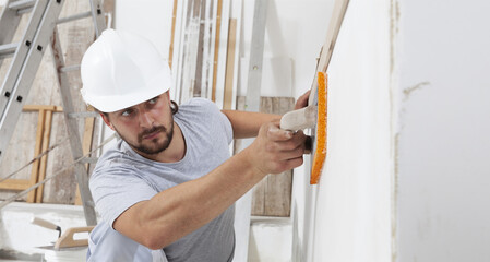 Construction worker are using sponge and plastering trowel to smooth the walls. Home improvement,...