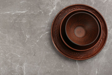 Set of clay dishes on grey marble table, top view. Space for text