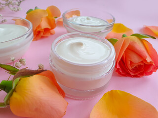 Obraz na płótnie Canvas cream cosmetic rose flower on colored background