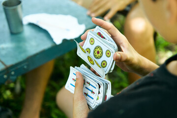 Personas Latinoamericanas jugando a las cartas de truco al aire libre. Familia jugando