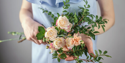 A woman in a blue dress is holding a small tenderness bouquet of flowers. Concept of spring, summer nice romantic mood