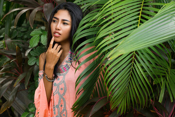 Beautiful asian girl in fashionable summer clothes and  accsessorises posing in tropical  portrait.